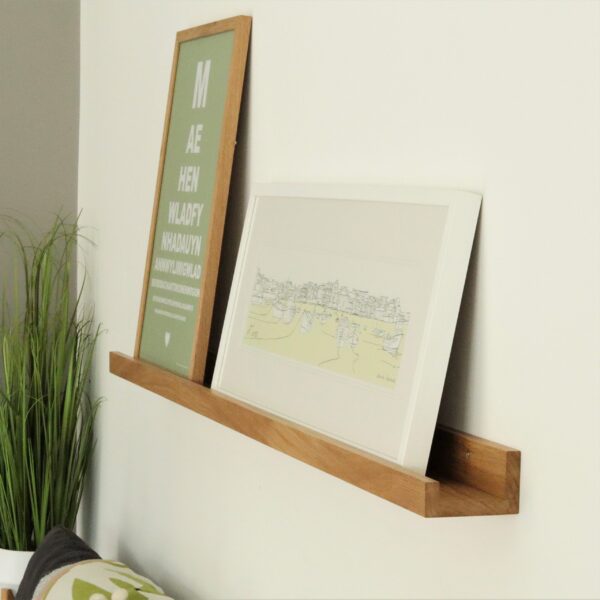 Floating oak shelf used to display photos and paintings