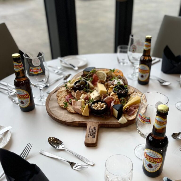 Oak Charcuterie serving board in the shape of the Pilsner icon for Wrexham Lager