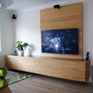 Floating media wall with storage and smoked blach glass top