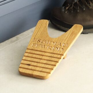 Boot jack with 'ESGIDIAU FFWRDD' engraved