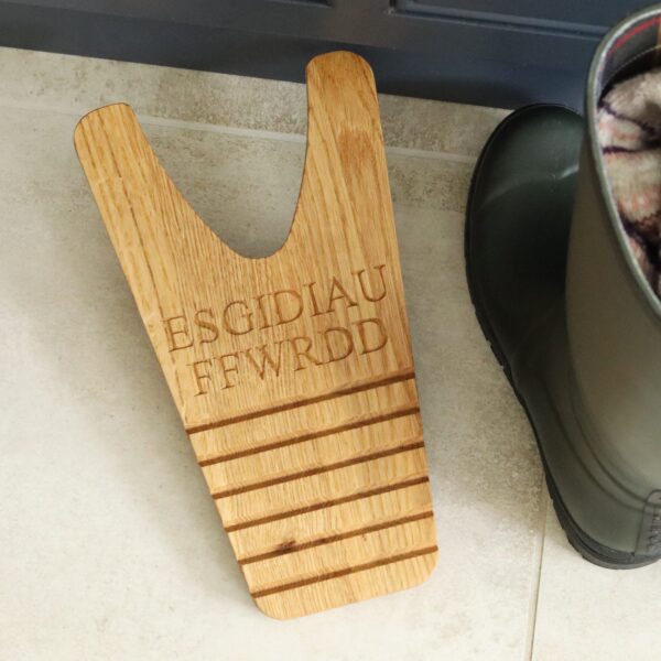 Solid oak boot jack / welly puller with 'ESGIDIAU FFWRDD' engravd into the wood